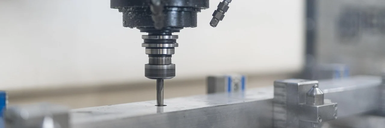 CNC spindle machining a metal workpiece before robotic part exchange